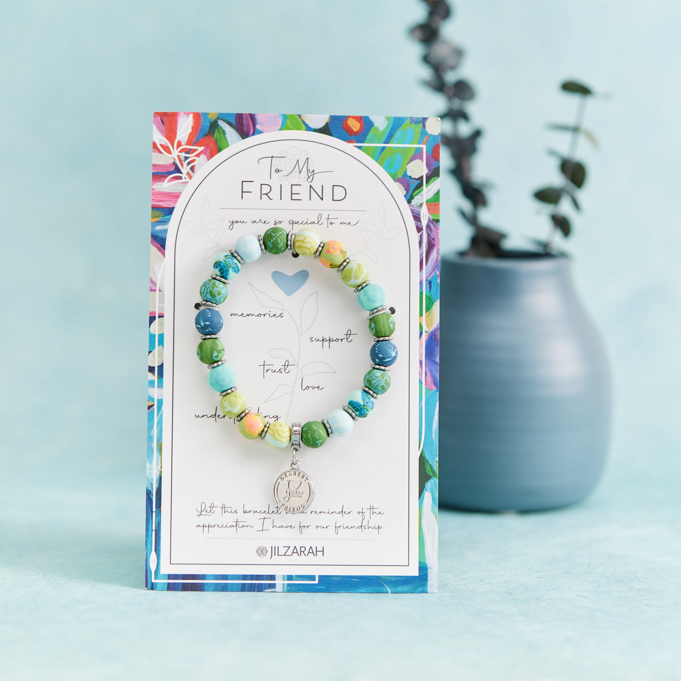 Friend Bracelet on its To My Friend card beside a small blue vase